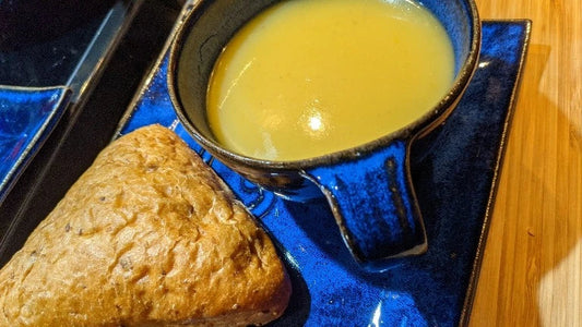Bol de potage onctueux à la courge poivrée garni de graines et herbes fraîches